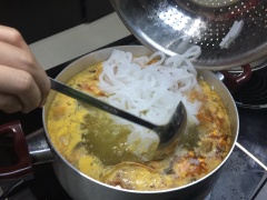 Cho nấm rơm xào vào cùng nồi nước bánh canh cua, nấu sối lại thì cho bánh canh vào, khuấy đều. Chờ nồi bánh canh cua sôi lại thì tắt bếp.
