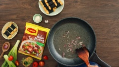 Bắc chảo nóng, phi thơm 5gr hành tím băm. Sau đó cho 40gr cà chua cắt nhỏ vào xào 2 phút, nêm 1 muỗng canh hạt nêm Maggi nấm hương, 1 muỗng canh đường xào thêm trong 1 phút.