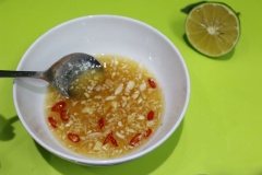 Pha hỗn hợp nước trộn gỏi với tỉ lệ 2 muỗng canh đường, 1 muỗng canh nước mắm và 1 muỗng canh nước cốt chanh. Khuấy hỗn hợp nước trộn cho tan đường. Thêm ớt băm và tỏi băm vào.