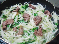 Cho thêm dầu ăn còn lại vào sau đó cho su hào và lá su hào non cắt nhỏ vào xào, cho 1 muỗng cà phê hạt nêm cho vừa vặn sau đó cho phần thịt bò vừa xào vào đảo cùng khoảng 2 phút thì tắt bếp