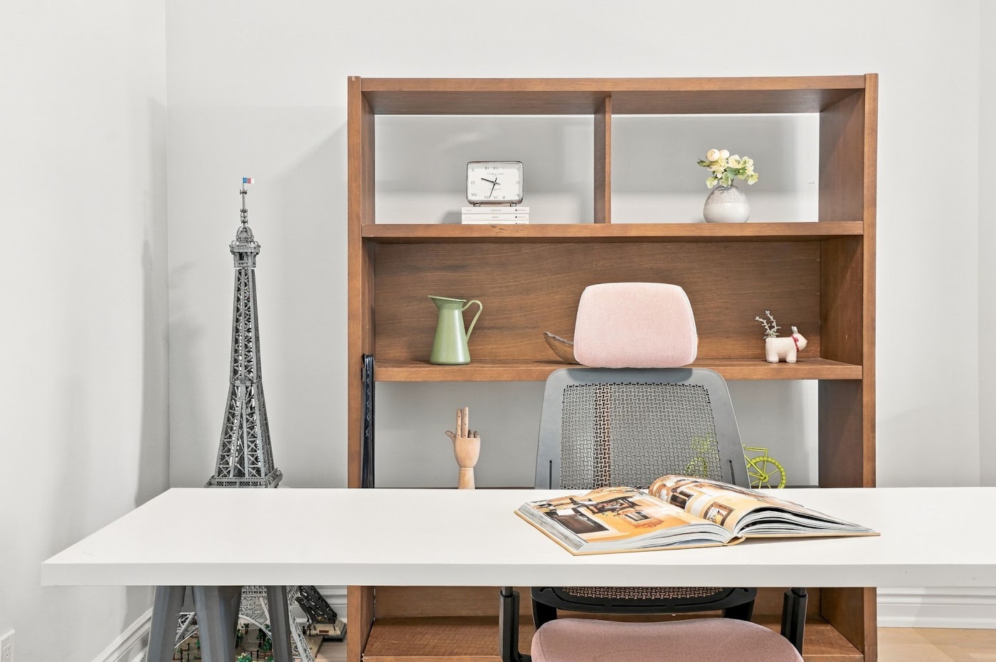 The den with a desk and open wood shelving