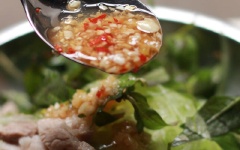 Cho bí đao, thịt heo, rau răm vào tô. Rưới đều hỗn hợp nước mắm vào, trộn đều.