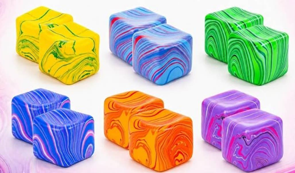 A miniature swirl cube squishy, roughly an inch across, in soft pastel colours