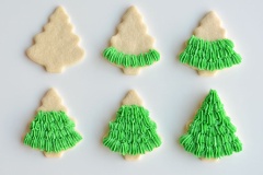 Cho kem vào túi bắt với đuôi hình hoa. Lần lượt bắt kem lên bánh cookie để tạo thành những tán lá của cây thông. Sau khi đã bắt hết kem là chúng ta đã hoàn thành món bánh xinh xắn này rồi đó.