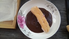 Đun tan chảy chocolate đen rồi đổ ra đĩa phẳng, nhúng 1 mặt bánh su vào cho dính chocolate, rắc thêm ít đậu phộng rang giã nhỏ là có thể dùng.