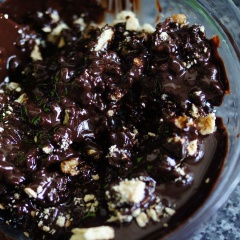 Cho phần chocolate chảy vào tô hỗn hợp hạt hồ đào, nho khô và bánh quy. Trộn đều.