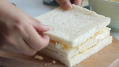 Dùng dao cắt bỏ rìa bánh sandwich, phết hỗn hợp trứng mayonnaise lên lát sandwich, sau đó kẹp một lát bánh, tiếp tục phết trứng mayo vào lát bánh. Cuối cùng đặt 1 lát sandwich, tạo thành 3 lớp sandwich và 2 lớp nhân.