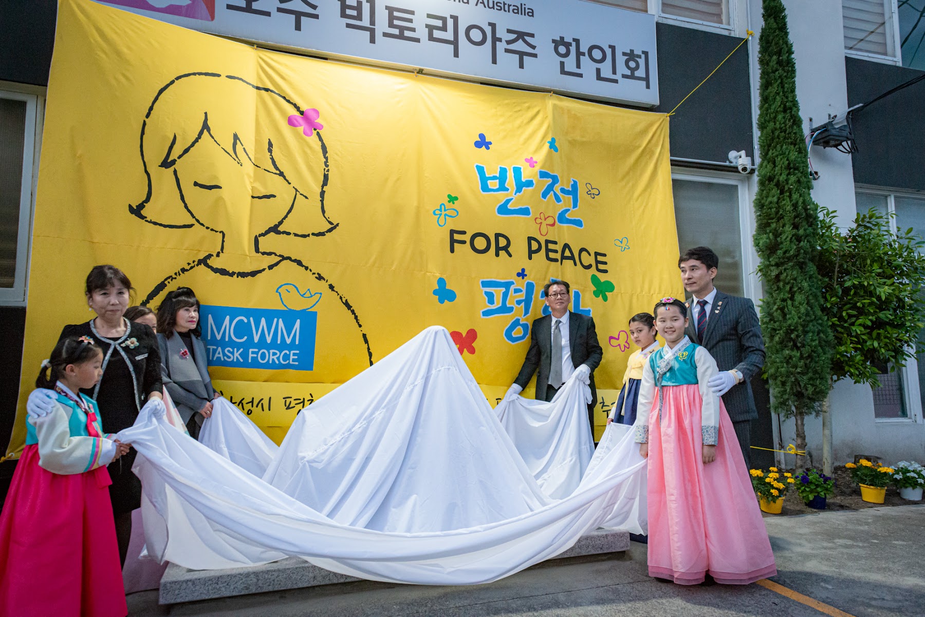 흰 천을 걷어 평화의 소녀상을 공개하는 제막 순간