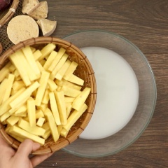 Đầu tiên, 700gr mua về gọt vỏ rửa sạch rồi để ráo nước, sau đó cắt khoai thành con chì dày khoảng 1cm. Chuẩn bị tô lớn, đổ 1 lít nước vo gạo vào thêm 1 muỗng canh đường cát rồi khuấy cho tan. Trút hết phần khoai lang đã cắt vào ngâm 30 phút để khoai bớt nhựa và không bị thâm đen. rồi vớt ra để thật ráo nước.
