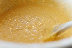 Trứng đập ra chén, thêm 250ml sữa tươi, 1 muỗng cà phê vani và bí ngô đã tán nhuyễn vào, đánh đều. Đổ hỗn hợp vào bột mì, khuấy đều đến khi bột nhuyễn, mịn.
