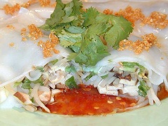 Tưới nước chấm lên đĩa phở cuốn tôm hấp và thưởng thức.