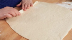 Tạo hình bánh bao Hàn Quốc: Phủ lên thớt và khối bột 2 muỗng bột mì khô. Đặt khối bột lên, dùng chày cán thành miếng bột mỏng kích cỡ chiều rộng khoảng 33cm, chiều sâu khỏng 35cm. Phết một lớp dầu ăn lên miếng bột, rắc 2 muỗng đường trắng lên cho đều khắp. Cuốn bột lại thành cuộn và lấy dao cắt thành khoảng 7 - 8 khúc bột.
