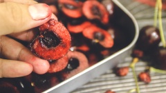 Cherry rửa sạch, tách đôi, bỏ cuống và hạt. Trộn cùng 110 gram đường còn lại, để khoảng 10 phút.