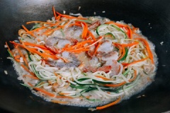Tiếp tục đun vào đảo trên lửa vừa khoảng 5-10 phút cho tất cả các nguyên liệu hòa quyện vào nhau và có phần đặc lại. Tuy nhiên, nếu miến quá đặc, bạn có thể đổ thêm nước dùng gà. Cho tôm và hành lá vào khoảng 2 phút là tắt bếp.