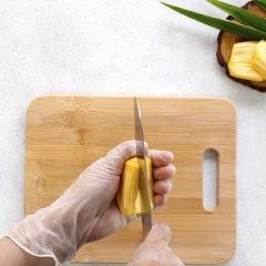 Để múi mít lên mặt phẳng, quan sát xem mít đứng thẳng được ở mặt nào thì dùng dao bổ giữa của mặt đối diện rồi lấy hột mít ra. Sau đó, nhồi xôi vào.