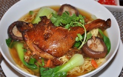 Cho mì vào tô, xếp đùi vịt lên trên, thêm cải thìa, tai nấm, hành lá cắt nhỏ, chan nước dùng vào là đã có tô mì vịt tiềm thơm ngon, nóng hổi cho cả nhà cùng thưởng thức.