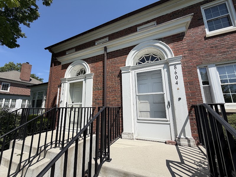 Arched entry at Historic Standish Estates before the repaint, worn white door surround against red brick