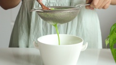 Đầu tiên, cắt lá dứa thành từng khúc và cho vào máy xay cùng với 100ml nước. Xay mịn hỗn hợp xong, cho thêm 100gr cơm dừa vào tiếp tục xay thêm 3 phút nữa. Sau đó lọc qua rây nước đầu để lấy nước cốt.