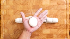 Để bột lên thớt, lăn dài. Sau đó chia bột thành những phần bằng nhau, vo tròn, đè hơi dẹp.