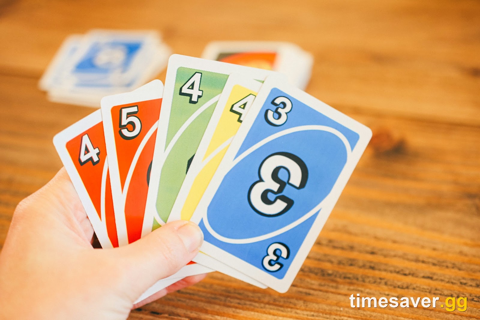 A hand of playing cards being selected and sorted, representing the new FC 27 Streamlined SBC item-score submission system