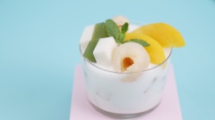 Thành phẩm: Cho vào tô đá nhuyễn, thêm 300ml sữa chua uống Đà Lạt Milk vào, sau đó thêm topping vải ngâm, đào ngâm, thạch sữa chua lá dứa rồi thưởng thức.