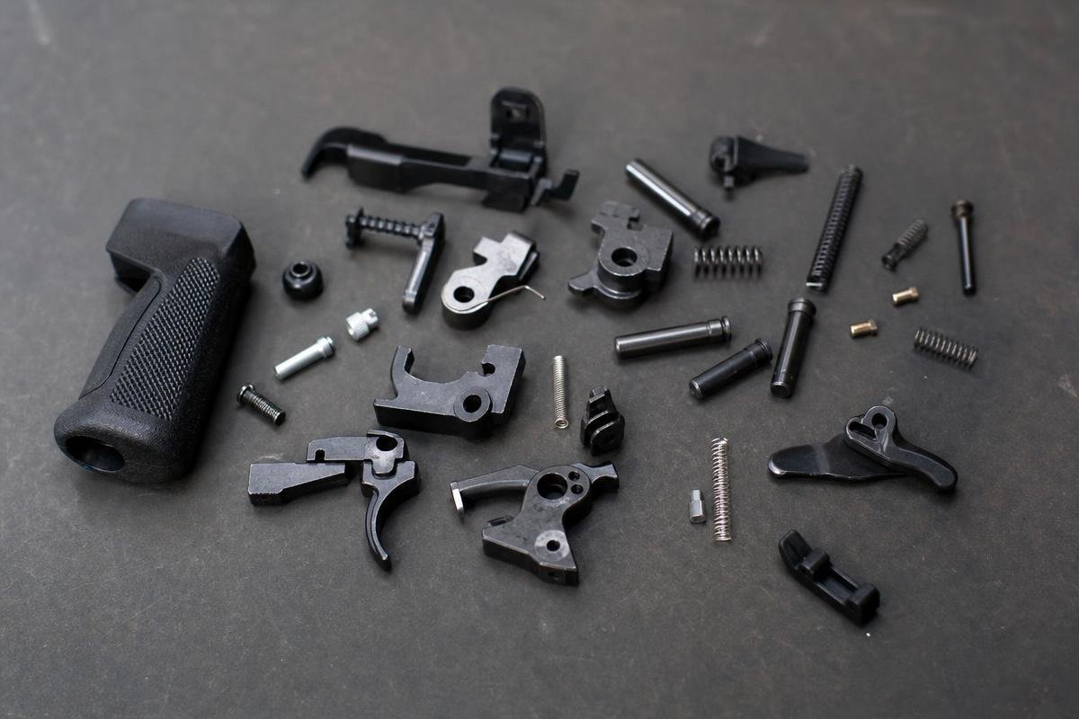 complete AR-15 lower parts kit components laid out including trigger group hammer springs and buffer assembly