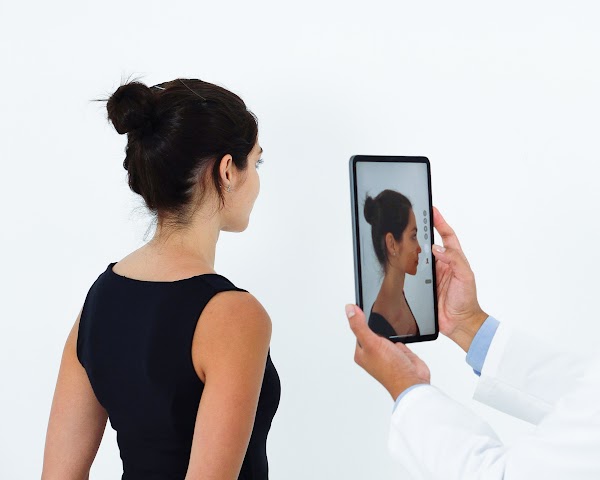 Un médecin prenant une photo du profil droit du patient avec une tablette pour créer un modèle 3D avec Crisalix.