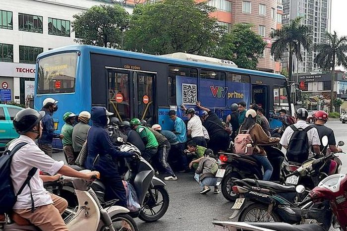 Cận cảnh người dân nâng xe buýt cứu tài xế mắc kẹt - Báo Sức Khỏe &amp; Đời Sống