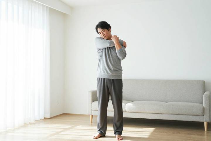明るい室内でストレッチをする男性