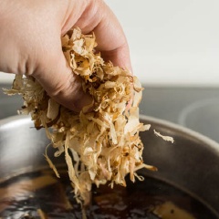 Cho cá bào katsuobushi vào rồi giảm lửa và đun tiếp trong 25 phút. Tắt lửa, để hỗn hợp nguội rồi cho vào lọ thủy tinh, để trong tủ lạnh qua đêm là có thể dùng được rồi.