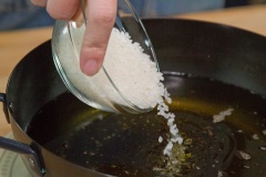 Sơ chế nguyên liệu: băm nhỏ 40g hạnh nhân, 30g nho khô, 40g hạt óc chó, chà là đỏ và để ra dĩa riêng. Gạo đem vo sạch và phơi cho gạo khô hoàn để khi chiên không bị văng dầu. Đun nóng chảo dầu, đổ gạo vào chiên cho nở bung, giòn giòn thì vớt ra cho ráo dầu.
