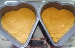 Lót giấy nến vào khuôn bánh hình trái tim. Cho hỗn hợp bánh quy vào khuôn, én chặt.