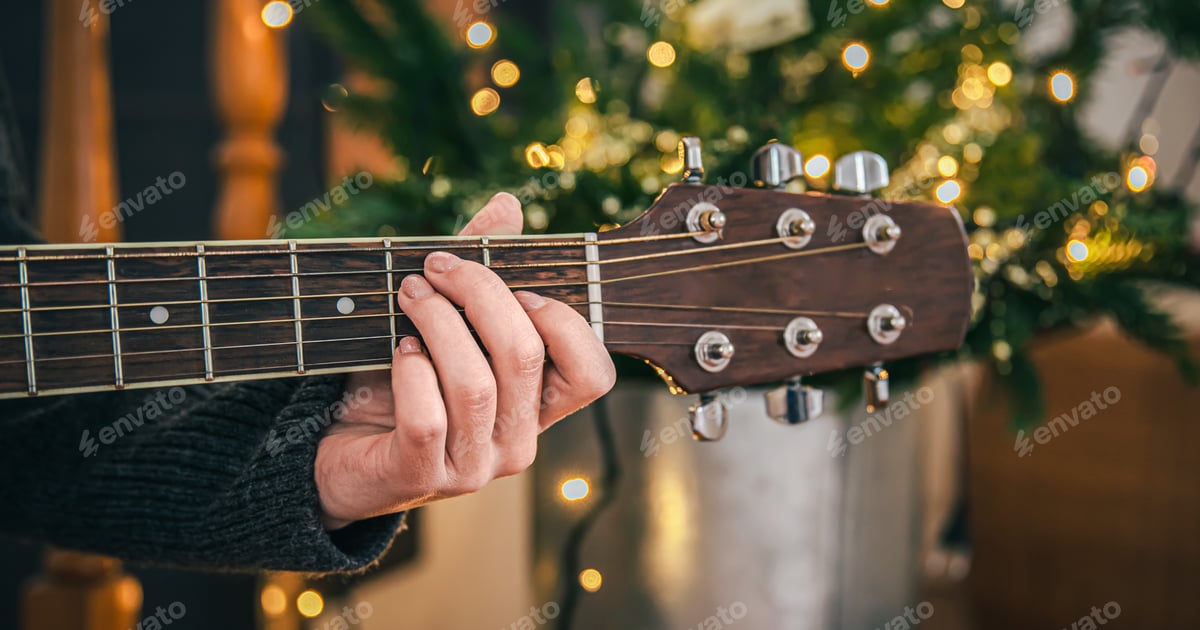 Acoustic Guitar Played in Front of Christmas Tree Free Download – Envato Elements