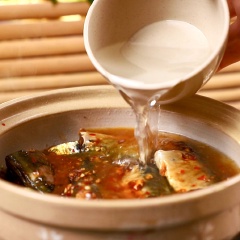 Cho 1 muỗng canh dầu ăn vào nồi đất, phi thơm 1 muỗng canh tỏi băm cho thơm, rồi cho cá nục vào cho săn, đổ hết phần nước ướp cá vào trong nồi, tiếp tục cho 300ml nước dừa tươi vào kho với lửa nhỏ trong 15 phút.