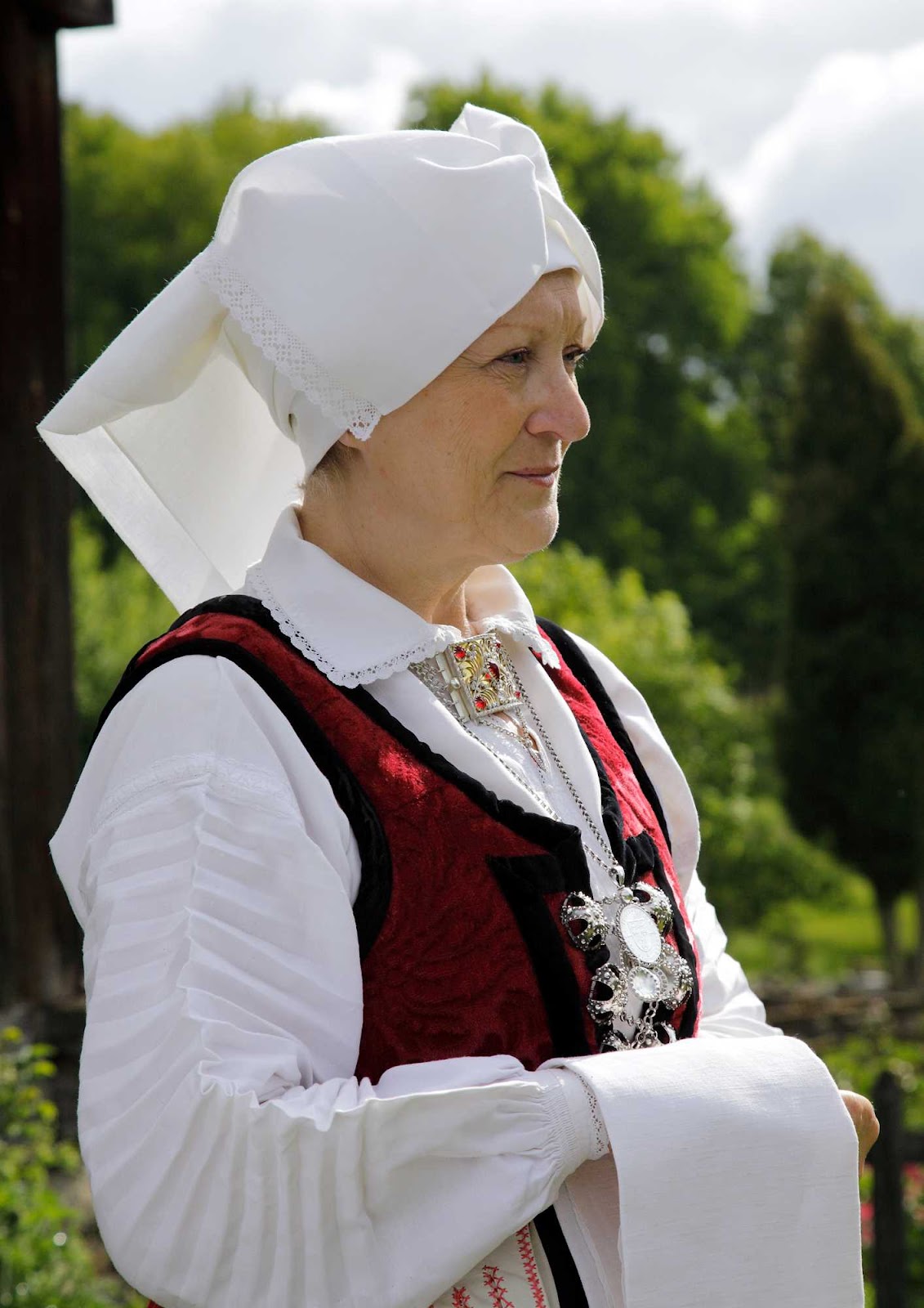 Överdel, s.k. opplöt med tvärveckade ärmar. Bandklut efter förlaga på Smålands museum.