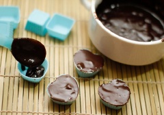Chuẩn bị khuôn hình trái tim nhỏ. Múc hỗn hợp chocolate đen tan chảy vào bên trong khuôn.