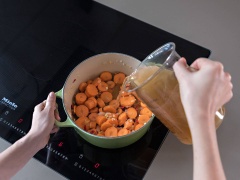 Cho tiếp cà rốt vào nồi và xào khoảng vài phút. Thêm nước dùng gà vào đun sôi, vặn nhỏ lửa lại và đun thêm 29 phút nữa hoặc đến khi cà rốt chín mềm.