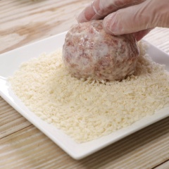 Chia phần thịt đã nhồi làm 6 phần đều nhau. Ấn dẹp đặt trứng gà luộc lên bọc kín các quả trứng lại. Lần lượt lăn các viên thịt bọc trứng qua 100gr bột chiên giòn đã pha với 300ml nước, rồi lăn qua bột chiên xù, phủ cho đều. Nếu trứng chưa đều bột có thể lăn tiếp một lớp bột chiên giòn rồi áo thêm một lớp bột chiên xù.