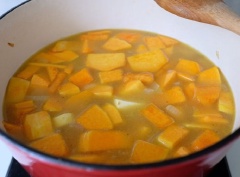 Bạn bắt nồi lên bếp cho nóng rồi cho 1 muỗng canh bơ vào để bơ tan chảy. Chờ bơ nóng thì cho tỏi và gừng vào phi thơm, sau đó cho hành tây vào xào cho đến khi hành tây chuyển sang màu trắng trong thì cho tiếp bí đỏ cùng khoai tây vào xào chừng 1 phút rồi cho nước dùng gà vào nấu cho đến khi khoai tây và bí đỏ nhừ thì tắt bếp, để nguội.