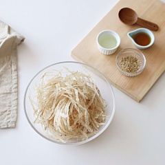 Cá khô bò dùng kéo cắt thành những sợi nhỏ và dài. Trong chén nhỏ trộn đều: 1/2 muỗng canh nước tương, 2 muỗng canh siro bắp, 2 muỗng canh rượu, 1 muỗng canh sốt mayonnaise, 1 muỗng canh dầu ăn, 1/2 muỗng canh tỏi băm và ít tiêu.