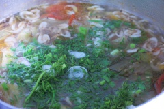 Dưa mềm cắt thêm trái ớt tươi vào nồi canh. Cuối cùng rắc hành, thì là rồi tắt bếp.