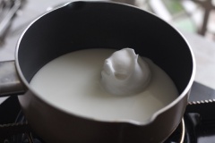 Đun 300 ml sữa ấm nóng (không để sôi). Dùng muỗng hoặc ice-cream scoop tạo hình vào cho vào nồi sữa. Nấu khoảng 3 phút thì lật mặt và nấu tiếp 3 phút nữa thì vớt ra.