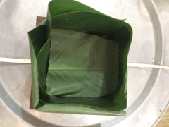 Lá dong sau khi trần xong, lau thật khô. Tùy theo kích thước của lá để bạn cần sử dụng 3 hay 4 lá dong cho 1 chiếc bánh. Đầu tiên đặt 1 chiếc lạt xuống dưới, đặt khuôn lên trên. Gấp đôi lá dong để tạo ra góc vuông sau đó đặt vào 1 góc của khuôn. Thực hiện với 3 góc còn lại. Vì mình sử dụng lá dong to nên chỉ cần 3 chiếc lá gấp vuông góc là đủ cho 4 góc khuôn. Sau đó xếp 1 miếng lá dong vào giữa lòng khuôn. (Miếng lá dong này tận dụng phần lá dong cắt thừa lúc trước để đặt vào).
