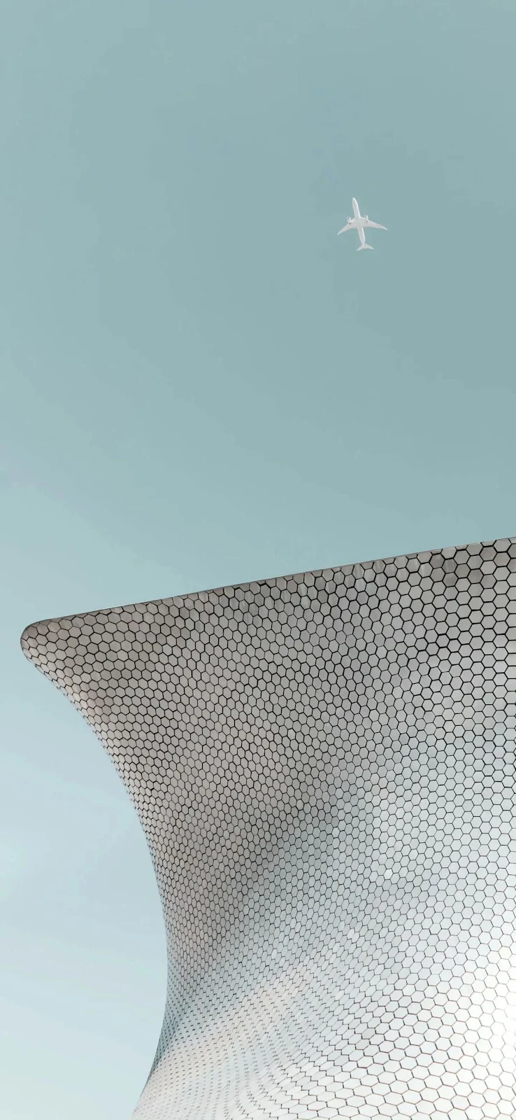 Airplane Flying Over Museo Soumaya - Minimalist Architectural Photography Full HD iPhone Wallpaper (1170x2535)