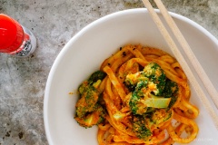 Cho bột cà ri đỏ, bơ hạnh nhân, bí đỏ nghiền trộn đều với nhau trong tô. Cho mì Udon cùng bông cải xanh vào để trộn. Nếu thấy quá khô, bạn có thể chan 2 muỗng canh nước luộc bông cải vào rồi trộn đều. bạn có thể nêm thêm muối tiêu nếu thích.