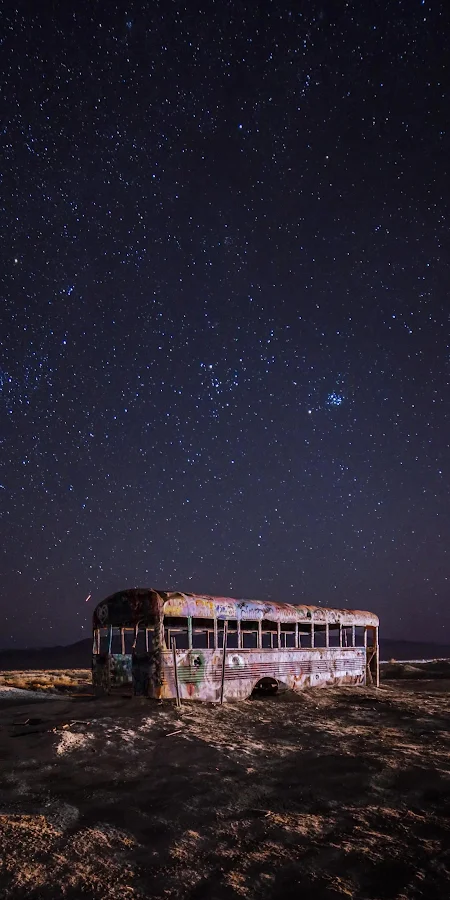 Abandoned Bus Under Starry Night 2K iPhone Phone Wallpaper