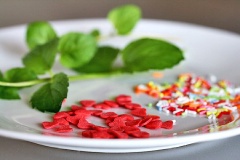 Gỡ túi kẹo ra bày lên đĩa và rửa sạch bạc hà, đồng thời ngắt luôn từng cọng lá ra. Xếp kẹo dưới đáy khay như hình bên.