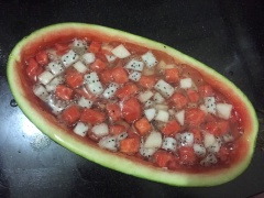 Cho phần trái cây trộn đều vào trong lòng quả dưa, từ từ đổ hỗn hợp nước thạch rau câu vào ngập mặt trái cây. Để cho thạch nguội bớt thì đặt vào trong ngăn mát tủ lạnh.