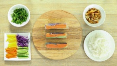 Chuẩn bị thêm 10 tờ bánh tráng mỏng để cuốn bánh tráng, 100gr bún tươi và 50gr rau thơm cắt nhỏ. Phết lên bún một lớp nước mỏng sau đó xếp lần lượt các nguyên liệu vào rồi cuộn chặt tay.