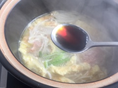 Nêm vào 1 muỗng canh nước tương, 1 muỗng canh ớt ngâm chua cắt nhỏ, ít muối và hạt nêm cho vừa miệng. Cuối cùng cho mì vào nấu cùng. Đun sôi khoảng 1 phút thì tắt bếp.